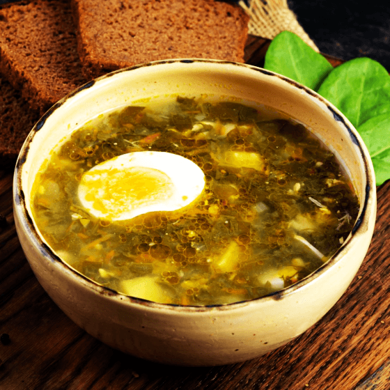 a bowl of borscht soup with egg, cabbage and potatoes
