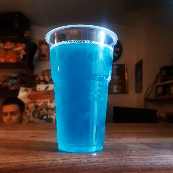 a glass of blueberry cider perched on a bar in Lviv