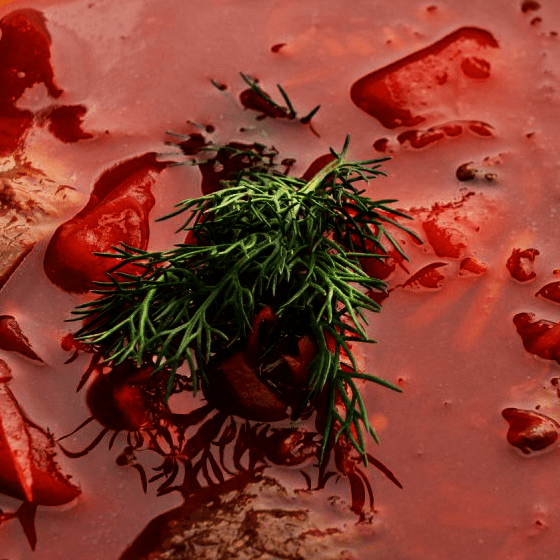 a bowl of borscht soup with beetroot, meat and potatoes