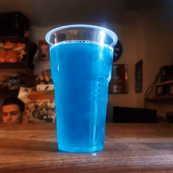 a glass of blueberry cider perched on a bar in Lviv