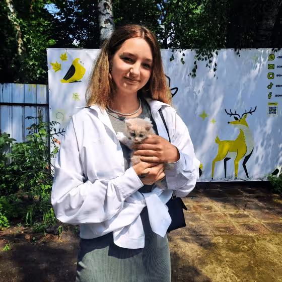 a volunteer cradling a kitten in a lviv animal shelter